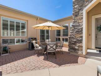Enjoy outdoor living with this charming patio featuring a gas grill and a dining set perfect for al fresco meals.