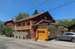 Discover this charming property featuring a multi-level home with a rustic wooden exterior and a welcoming balcony.