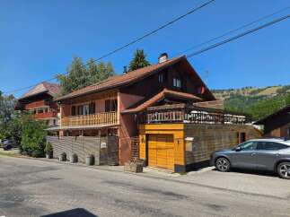 Discover this charming property featuring a multi-level home with a rustic wooden exterior and a welcoming balcony.