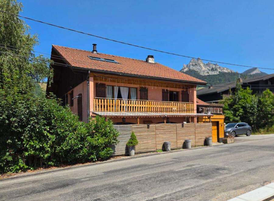 Charming alpine home featuring a spacious wooden balcony perfect for enjoying mountain views.