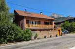 Charming alpine home featuring a spacious wooden balcony perfect for enjoying mountain views.