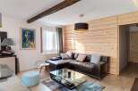 Experience cozy living in this charming room featuring a dark leather sectional sofa adorned with plush throw pillows.