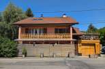 Charming two-story home featuring a spacious wooden balcony perfect for outdoor relaxation and entertaining.