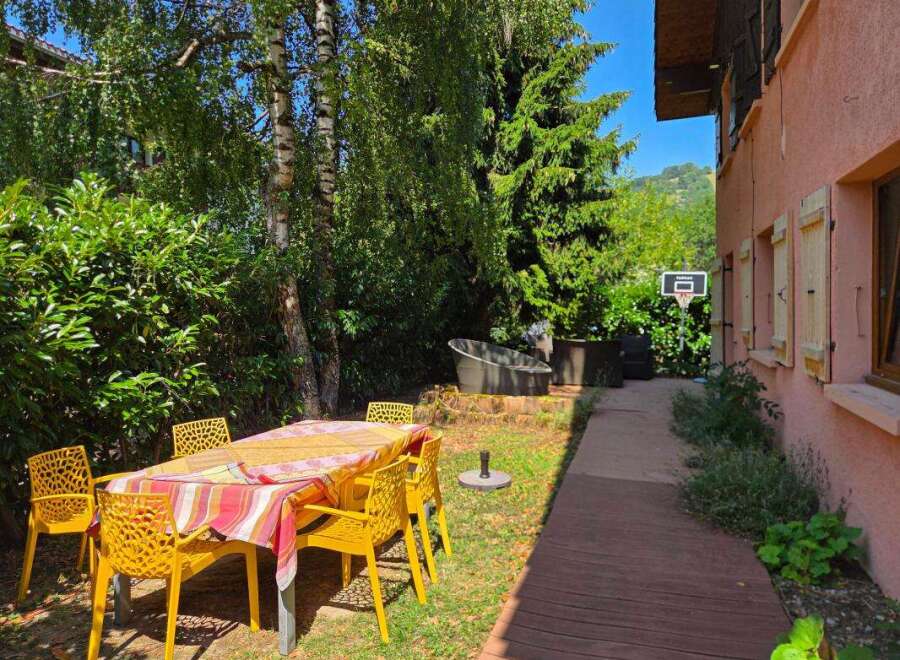 Enjoy outdoor living with this charming backyard featuring a dining set perfect for al fresco meals.