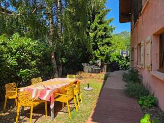 Enjoy outdoor living with this charming backyard featuring a dining set perfect for al fresco meals.