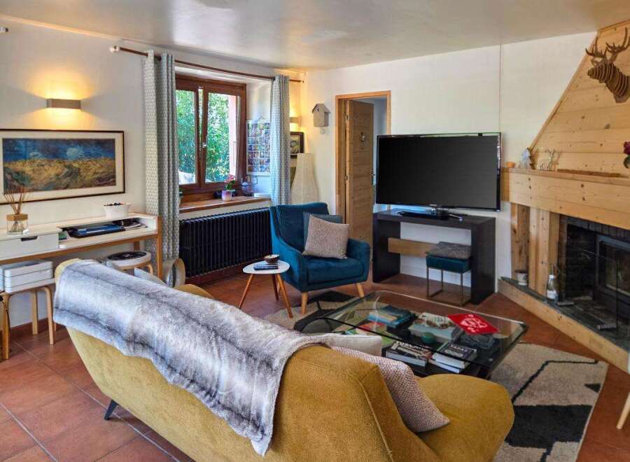 Experience cozy living in this charming living room, featuring a plush yellow sofa adorned with a faux fur throw, perfect for relaxing evenings.