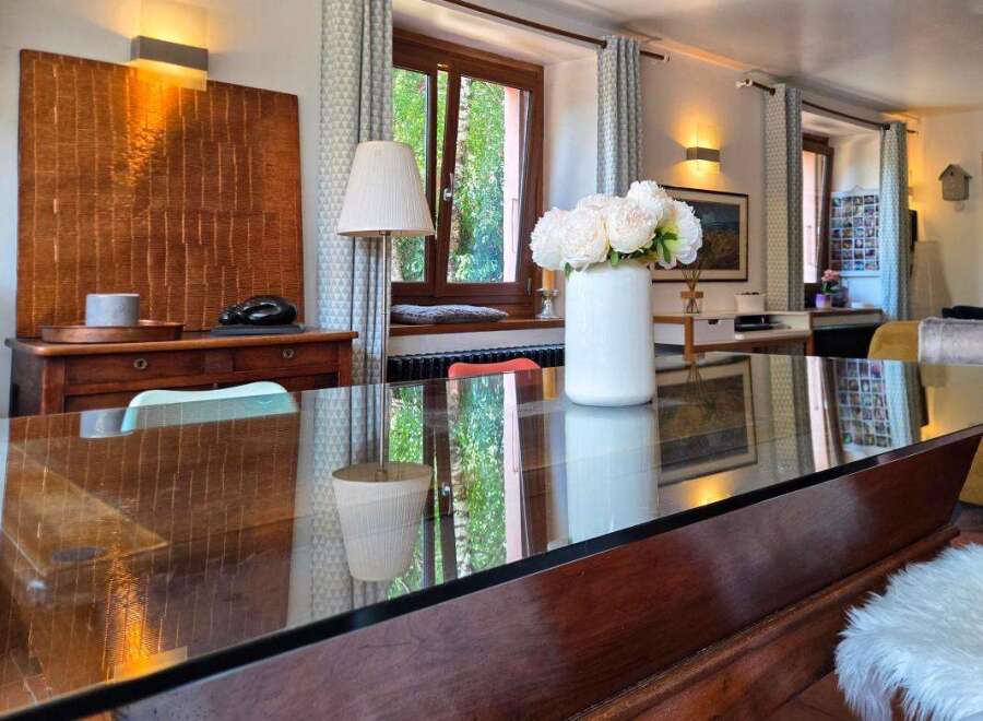 Experience elegant dining in this beautifully appointed space, featuring a sleek glass-top table that reflects the natural light.