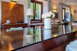 Experience elegant dining in this beautifully appointed space, featuring a sleek glass-top table that reflects the natural light.