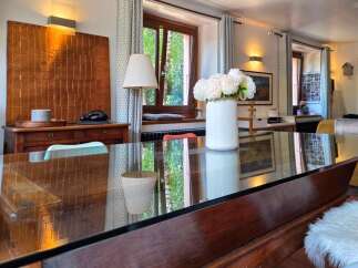 Experience elegant dining in this beautifully appointed space, featuring a sleek glass-top table that reflects the natural light.