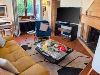 This cozy living room features a comfortable mustard-yellow sofa and a plush teal armchair, perfect for relaxing.