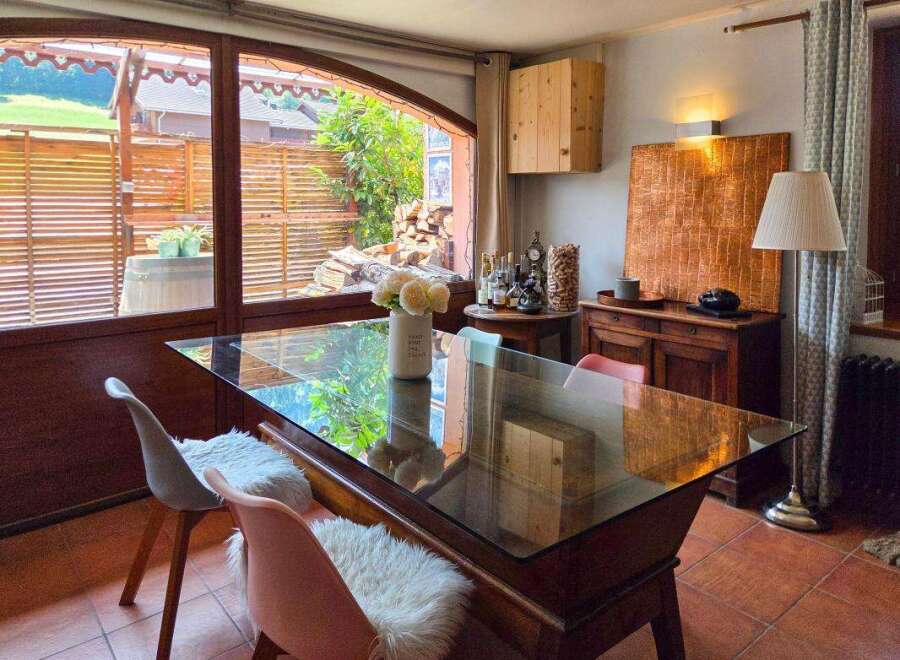Enjoy a charming dining experience in this inviting space, featuring a sleek glass-top table perfect for intimate gatherings.