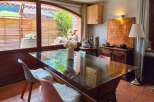 Enjoy a charming dining experience in this inviting space, featuring a sleek glass-top table perfect for intimate gatherings.