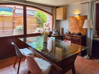 Enjoy a charming dining experience in this inviting space, featuring a sleek glass-top table perfect for intimate gatherings.