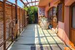 Discover this charming property featuring a rustic wooden porch with a slatted fence and a covered walkway, perfect for enjoying the outdoors.