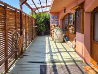 Discover this charming property featuring a rustic wooden porch with a slatted fence and a covered walkway, perfect for enjoying the outdoors.