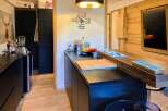 Discover this modern kitchen featuring sleek black cabinetry and a stunning wooden countertop island, perfect for meal preparation and casual dining.