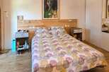 Discover this charming bedroom featuring a comfortable bed with a unique patterned duvet and a rustic wooden headboard.