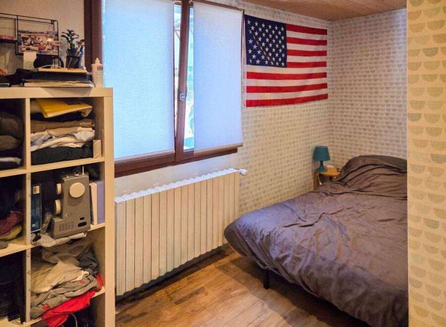 This cozy bedroom features a comfortable bed with a dark duvet, perfect for relaxation.