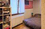 This cozy bedroom features a comfortable bed with a dark duvet, perfect for relaxation.
