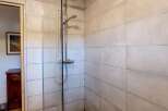 Step into a refreshing shower experience with this modern bathroom featuring a sleek chrome showerhead and controls.