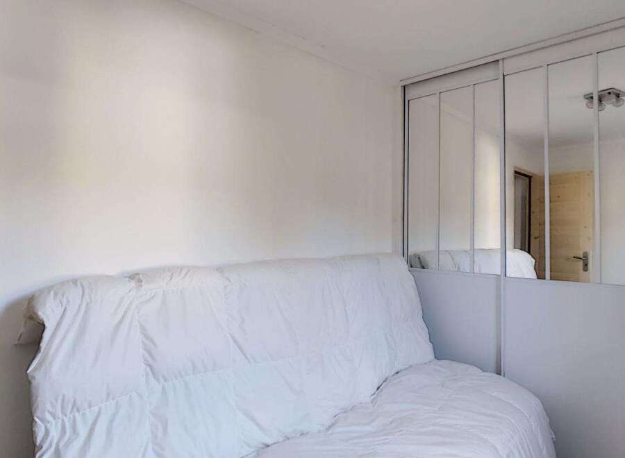Discover this cozy room featuring a comfortable white sofa, perfect for relaxation.