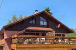 Charming wooden chalet with a spacious balcony offering scenic views.
