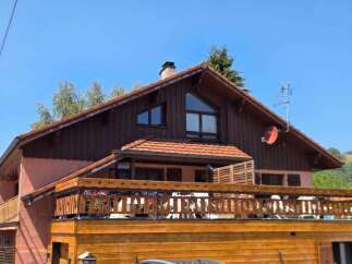 Charming wooden chalet with a spacious balcony offering scenic views.