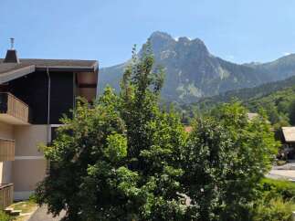 Experience breathtaking mountain views from this property, nestled amidst lush greenery.