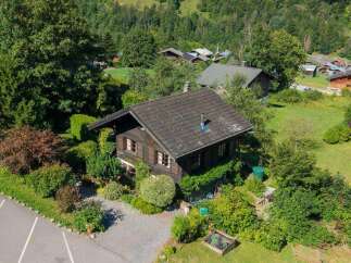 Nestled amidst lush greenery and rolling hills, this charming wooden chalet offers a serene mountain retreat.