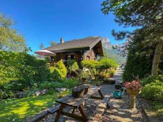 Escape to this charming wooden cabin nestled amidst lush greenery and breathtaking mountain views.