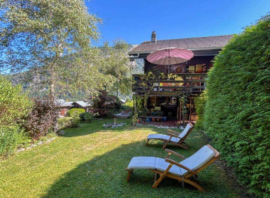 Enjoy a serene mountain getaway in this charming wooden chalet, complete with a spacious deck and lush green lawn perfect for relaxation.