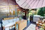 Enjoy outdoor living on this charming wooden deck, complete with a comfortable seating area and a built-in grill perfect for summer barbecues.
