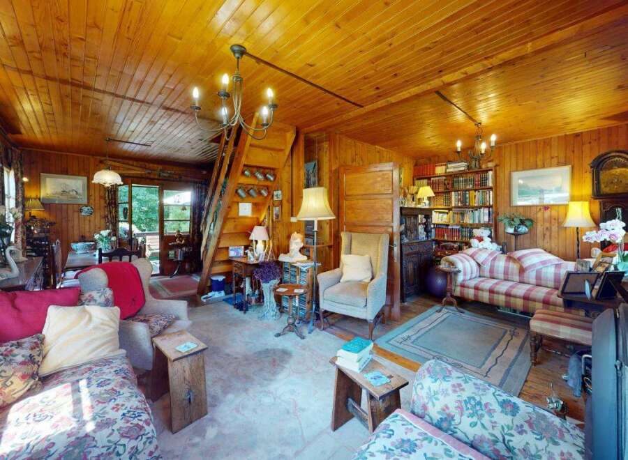 Step into this charming rustic living room, featuring warm wood-paneled walls and a cozy atmosphere.