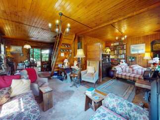 Step into this charming rustic living room, featuring warm wood-paneled walls and a cozy atmosphere.