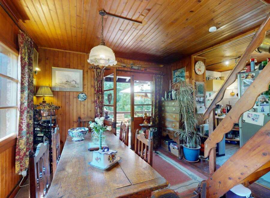 Experience rustic charm in this cozy dining area, featuring warm wood paneling throughout and a large wooden table perfect for family gatherings.