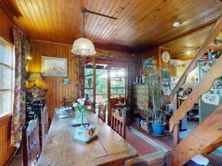 Experience rustic charm in this cozy dining area, featuring warm wood paneling throughout and a large wooden table perfect for family gatherings.