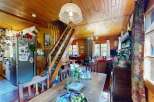 Step into this charming rustic home featuring a cozy living area with a wood-burning stove and a dining space perfect for family gatherings.