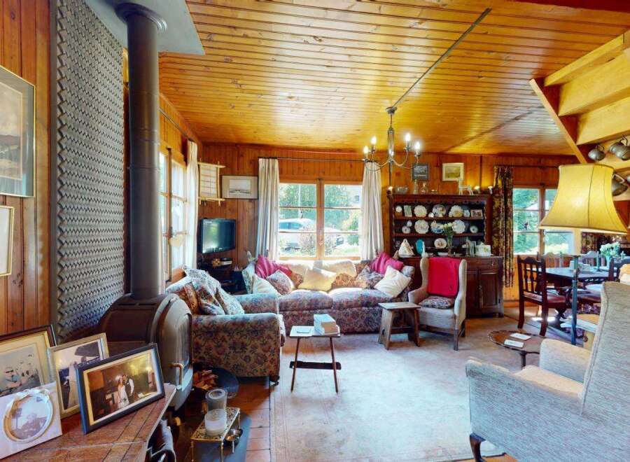 Step into this charming, rustic living room featuring a cozy fireplace and ample natural light.