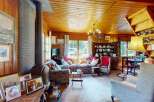 Step into this charming, rustic living room featuring a cozy fireplace and ample natural light.