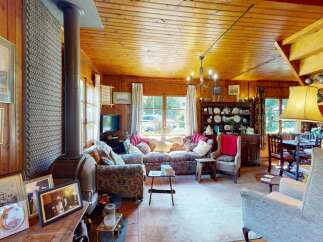 Step into this charming, rustic living room featuring a cozy fireplace and ample natural light.