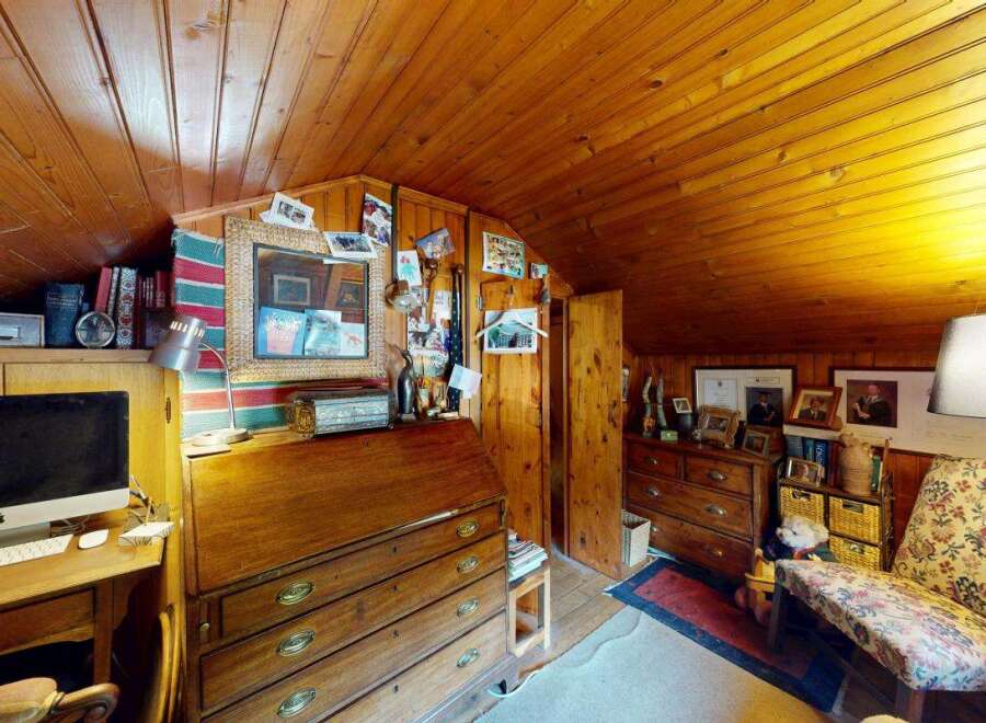 Discover this charming attic room, featuring warm wood paneling on the walls and ceiling, creating a cozy and inviting atmosphere.