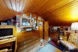 Discover this charming attic room, featuring warm wood paneling on the walls and ceiling, creating a cozy and inviting atmosphere.