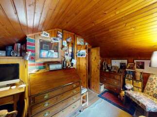 Discover this charming attic room, featuring warm wood paneling on the walls and ceiling, creating a cozy and inviting atmosphere.