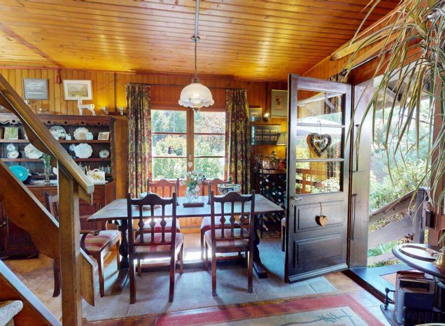 Step into a charming dining area featuring a rustic wooden table and chairs, perfect for intimate meals.