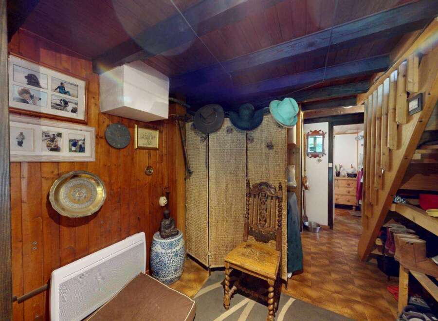 Discover rustic charm in this cozy interior featuring warm wood paneling and exposed beams.