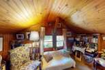 Cozy attic living space featuring warm wood paneling and a vaulted ceiling.