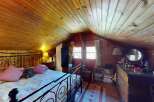 Step into this charming rustic bedroom featuring a cozy wooden ceiling and walls, creating a warm and inviting atmosphere.