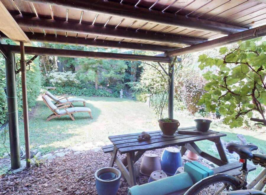Enjoy outdoor living under this charming wooden pergola, perfect for relaxing or entertaining.