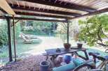 Enjoy outdoor living under this charming wooden pergola, perfect for relaxing or entertaining.