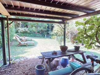 Enjoy outdoor living under this charming wooden pergola, perfect for relaxing or entertaining.